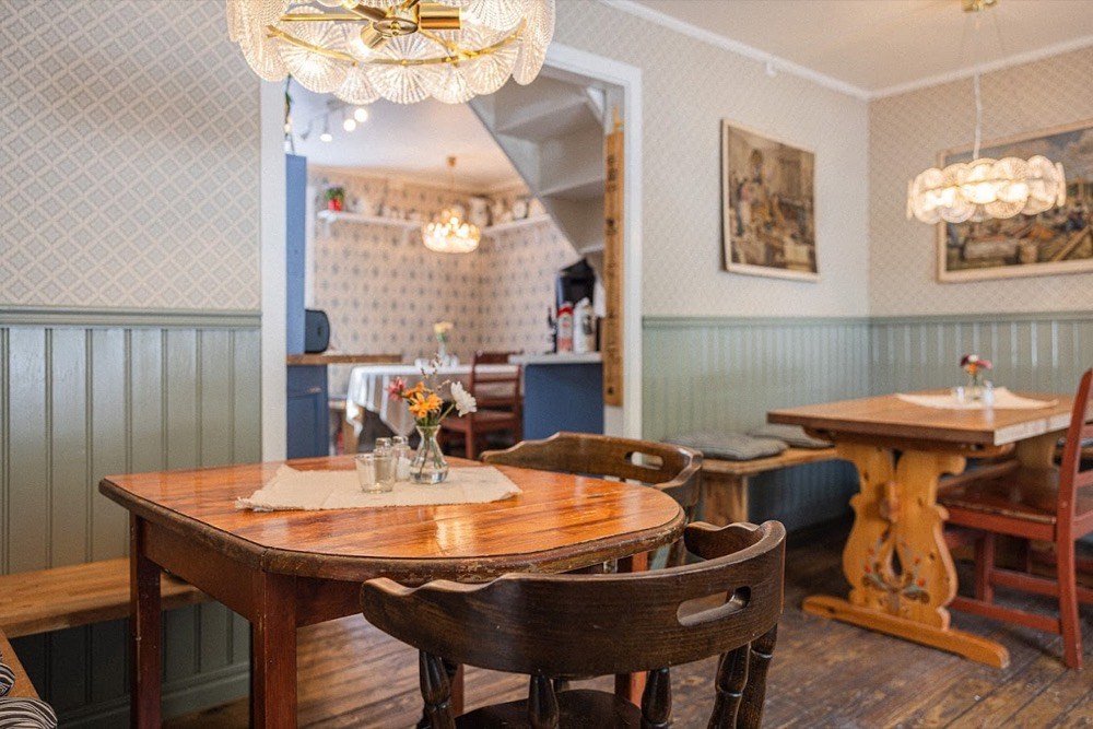 Sittplatser med träbord inne på Hantverkscafét